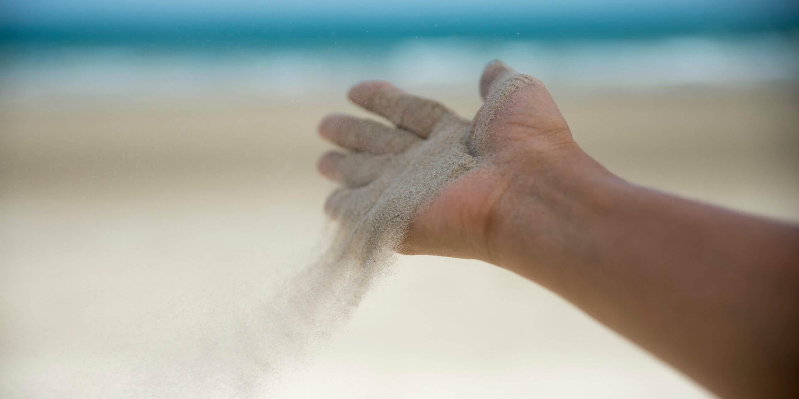 Freedom,release and wellness concept.Hand of woman release sand with seabeach background